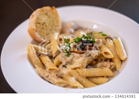 Penne Pasta with truffle sauce with bacon and garlic bread. Penne Pasta with truffle sauce with bacon and garlic bread. 134814391