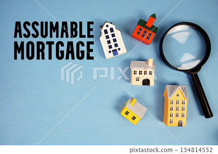 Assumable Mortgage text with house models and magnifying glass on blue background Assumable Mortgage text with house models and magnifying glass on blue background 134814552