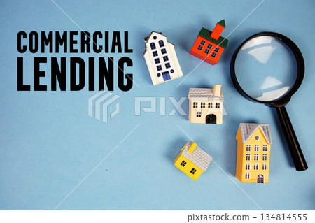 Commercial Lending text with house models and magnifying glass on blue background 134814555