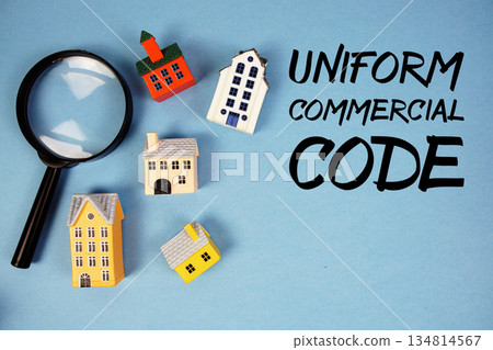 UCC Uniform Commercial Code text with house models and magnifying glass on blue background UCC Uniform Commercial Code text with house models and magnifying glass on blue background 134814567