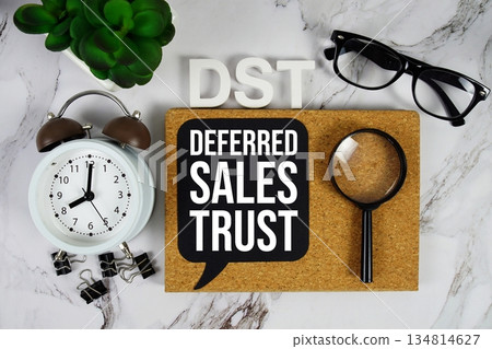 DST - Deferred Sales Trust acronym with calculator, alarm clock and magnifying glass, Business concept background DST - Deferred Sales Trust acronym with calculator, alarm clock and magnifying glass, Business concept background 134814627