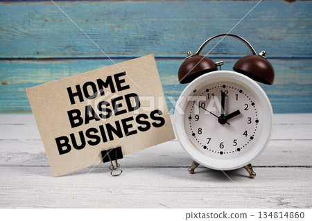 Home Based Business text written on paper card with alarm clock on wooden background Home Based Business text written on paper card with alarm clock on wooden background 134814860