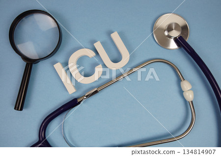 ICU abbreviation of Intensive Care Unit alphabet letters with magnifying glass and stethoscope on blue background 134814907