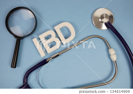 IBD abbreviation of Inflammatory Bowel Disease alphabet letters with magnifying glass and stethoscope on blue background 134814909