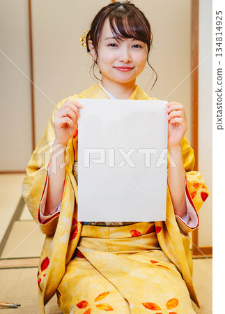 一位身穿和服的年輕女子正在寫書法 一位身穿和服的年輕女子正在寫書法 134814925
