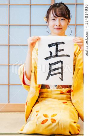 一位身穿和服的年輕女子正在寫書法 一位身穿和服的年輕女子正在寫書法 134814936
