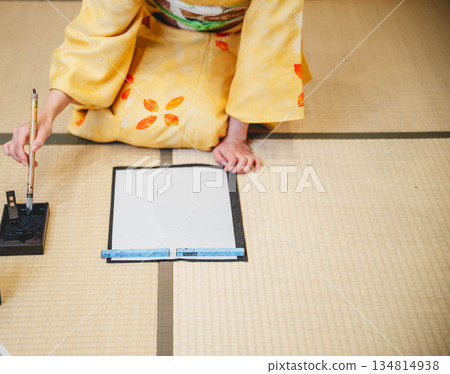 A young woman wearing a kimono writing calligraphy A young woman wearing a kimono writing calligraphy 134814938