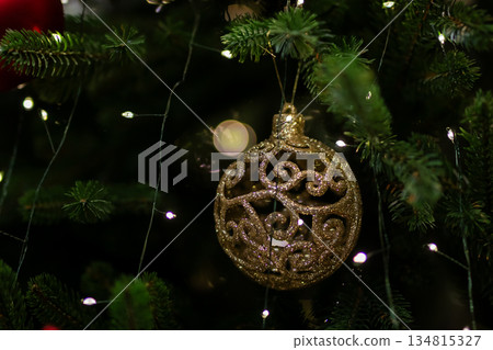Sophisticated gold adornment decorated with shimmering accents on evergreen branches Sophisticated gold adornment decorated with shimmering accents on evergreen branches 134815327