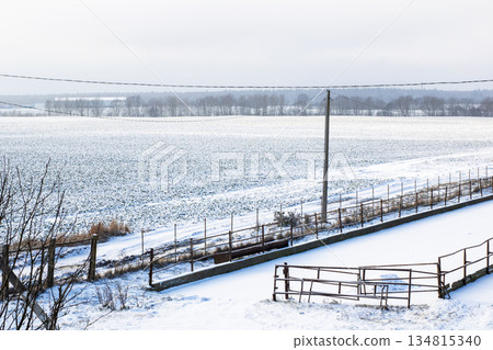 Serene winter landscape illustrating icy terrain reaching distant skyline enveloped in snow 134815340