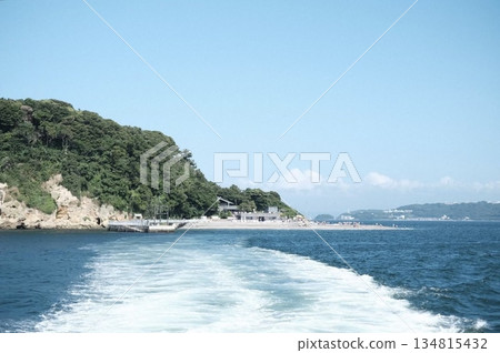 一艘船航行在海上，遠處是一座島嶼。 134815432