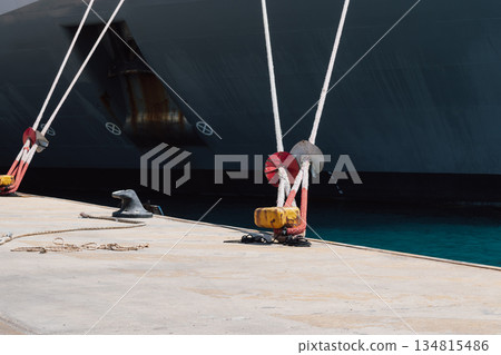 Mooring of a vessel in the port using mooring lines to a bollard on the quay 134815486