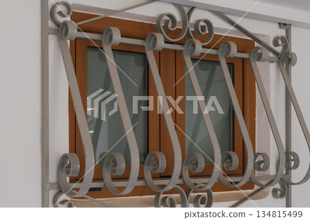 Small window with decorative wrought iron grilles Small window with decorative wrought iron grilles 134815499