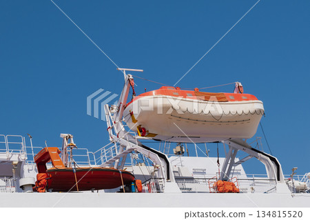 Lifeboats on the side of a cruise liner on a sunny day Lifeboats on the side of a cruise liner on a sunny day 134815520