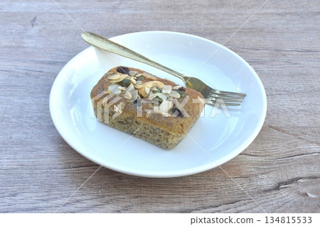 butter banana cake topping peanut and whole grain couple raisin with golden fork on plate 134815533