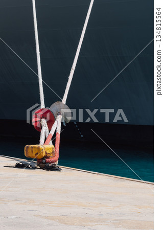 Mooring of a vessel in the port using mooring lines to a bollard on the quay 134815564
