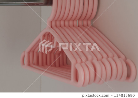 Children's plastic hangers for girls clothes in empty wardrobe 134815690