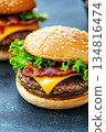Gourmet cheeseburger with melted cheese, fresh lettuce, and crispy bacon served on a sesame seed bun for an appetizing meal experience 134816474