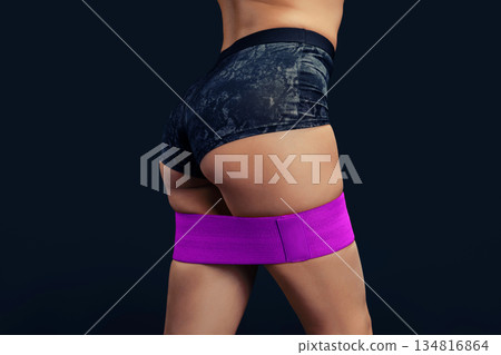 Woman exercises with resistance band during workout session at gym Woman exercises with resistance band during workout session at gym 134816864