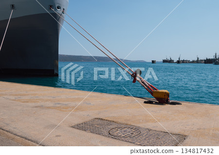 Mooring of a vessel in the port using mooring lines to a bollard on the quay 134817432