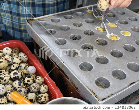 The photographer skillfully cracked open the quail eggs and poured them into molds to cook. The photographer skillfully cracked open the quail eggs and poured them into molds to cook. 134818062