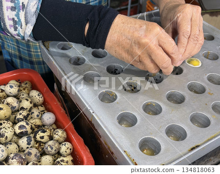 The photographer skillfully cracked open the quail eggs and poured them into molds to cook. The photographer skillfully cracked open the quail eggs and poured them into molds to cook. 134818063