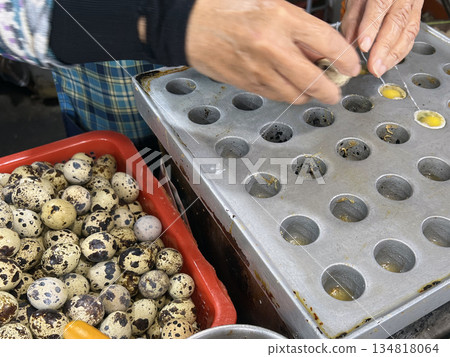 The photographer skillfully cracked open the quail eggs and poured them into molds to cook. The photographer skillfully cracked open the quail eggs and poured them into molds to cook. 134818064