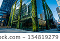 green plants and garden on modern glass skyscraper office building, nature and contemporary architecture, balance and harmony of environment and human, sustainability of ecosystem 134819279