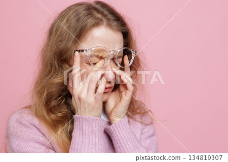 Side view portrait of woman pressing eyes in glasses showing dry eye irritation and headache from screen fatigue 134819307
