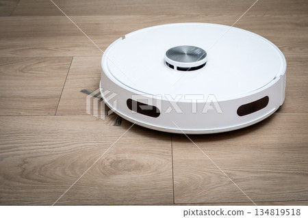 Autonomous Robot Vacuum Cleaner Operating On Clean Wooden Floor Surface Autonomous Robot Vacuum Cleaner Operating On Clean Wooden Floor Surface 134819518