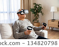 An elderly man wearing modern virtual reality glasses 134820798