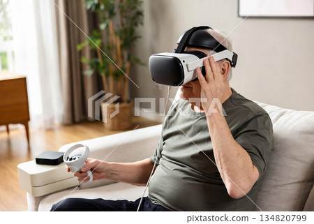 An elderly man wearing modern virtual reality glasses 134820799
