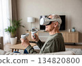 An elderly man wearing modern virtual reality glasses 134820800