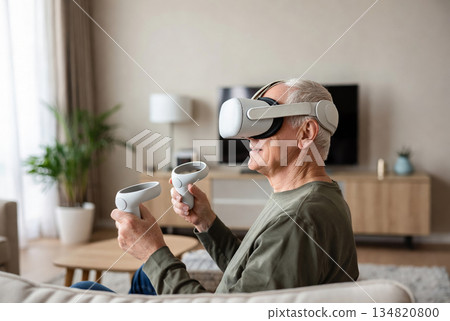 An elderly man wearing modern virtual reality glasses 134820800