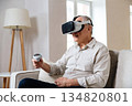 An elderly man wearing modern virtual reality glasses 134820801