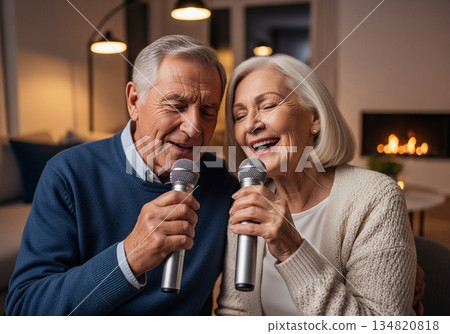Elderly man and woman singing karaoke together in a cozy modern living room 134820818