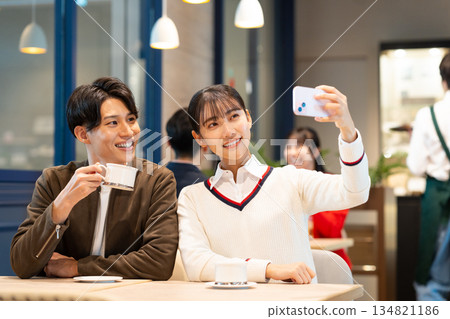 Young couple taking photos in a cafe Young couple taking photos in a cafe 134821186