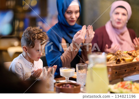 Muslim family sharing iftar in a restaurant decorated for Ramadan celebrations Muslim family sharing iftar in a restaurant decorated for Ramadan celebrations 134821196