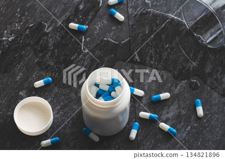 Tablets. Dropping pills and a glass of water from the hands. Tablets. Dropping pills and a glass of water from the hands. 134821896
