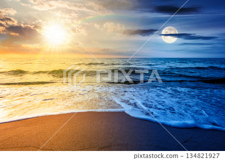 sand beach at the sea for summer solstice vacation. day and night time change concept. beautiful sunrise at perfect coast with calm waves, sun and moon. landscape for duality and transition template sand beach at the sea for summer solstice vacation. day and night time change concept. beautiful sunrise at perfect coast with calm waves, sun and moon. landscape for duality and transition template 134821927