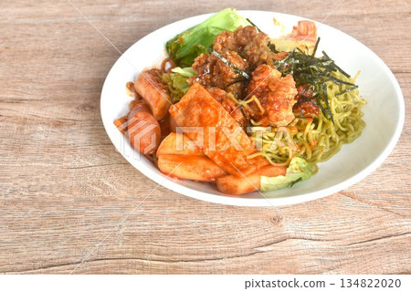 Korean vegetable noodles topping tokpokki slice pork sausage and cabbage with tofu dressing spicy sauce couple fried chicken topping dry seaweed on plate 134822020