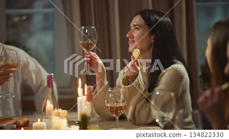 Woman drinking wine during relaxed dinner with friends. Woman drinking wine during relaxed dinner with friends. 134822330