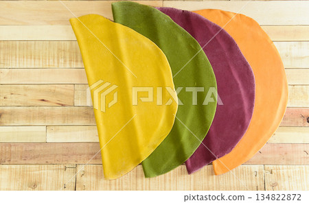Colored dough for noodles stretched on the table, Italian cuisine made at home Colored dough for noodles stretched on the table, Italian cuisine made at home 134822872