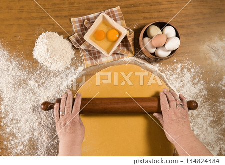 Hands cutting noodles with ingredients on the table, homemade italian food. Hands cutting noodles with ingredients on the table, homemade italian food. 134824384