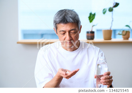 Senior men taking medicines and supplements Senior men taking medicines and supplements 134825545