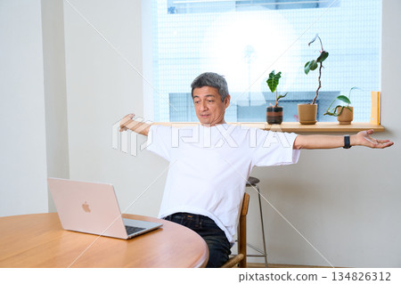 Senior man stretching, computer, working from home, teleworking 134826312