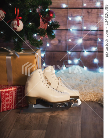 Women's skates next to an old leather suitcase and a Christmas tree. Christmas Decorations Women's skates next to an old leather suitcase and a Christmas tree. Christmas Decorations 134826389