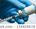doctor's hand holds a syringe and a blue vaccine bottle at the hospital. Health and medical concepts. 134826618