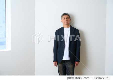 Senior man standing in a jacket and jeans 134827960