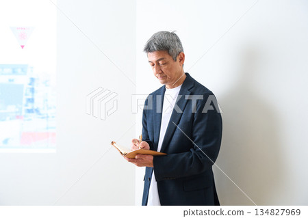 Senior man standing in a jacket and jeans 134827969