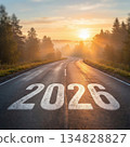 Looking ahead to 2026: A road to future vision. The image features the road towards 2026 with a beautiful sunrise sky and mountains in background. 134828827
